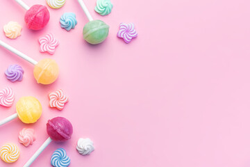 Fototapeta na wymiar Sweet lollipops and candies on pink background