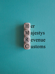 HMRC her majesty revenue and customs symbol. Concept words HMRC her majesty revenue and customs on cubes on beautiful blue background. Business HMRC revenue and customs concept. Copy space