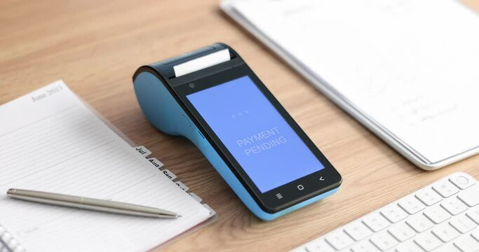 Woman pays with credit card and wireless terminal in office slow motion. Contemporary technology of banking service. POS machine on desk