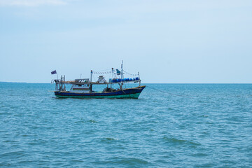 Small fishing boat sailing in a open sea. Fishing boat floating on the water, blue sea.