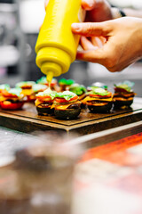 chef hand cooking set mini hamburgers, mini burgers on restaurant kitchen