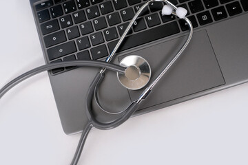 medical stethoscope, the doctor's tool lies on the laptop keyboard, the concept of a physician's workplace, checking the health of the computer for viruses, repairing the gadget