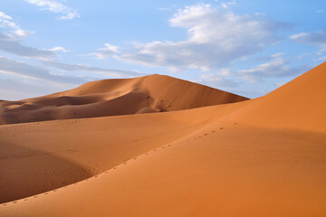Panoramic shot of dunes in Merzouga, Sahara desert, Morocco, on a sunny day.	
