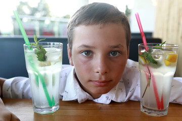 Child face between two glasses of lemonade