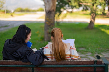 Two high school girls sitting on a bench