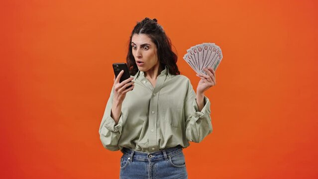 Young woman checks her smartphone, rejoices at successful sports betting, winning lottery or jackpot