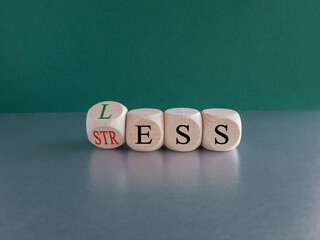 Having less stress or being stress-less. The word 'STRESS' and 'LESS' on wooden cubes. Beautiful green background, copy space.