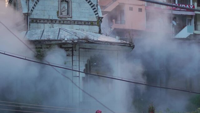 Closeup shot of Shiva temple besides the Paravati river at Manikaran in Himachal Pradesh, India. Steam from hot springs near the temple in front of temple. Shiva temple at Manikaran in winter. 