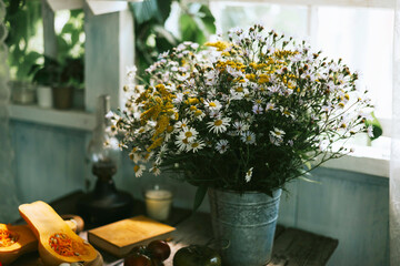 a bucket of daisies on a rustic table