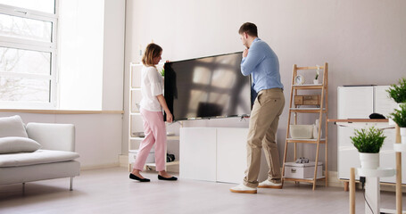 Smiling Young Couple Carrying New Television