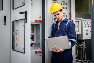 Electrical engineer working in control room. Electrical engineer man checking Power Distribution Cabinet in the control room