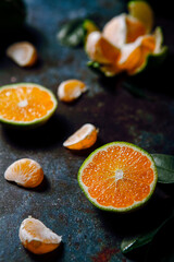 Green tangerines on a dark marble tabletop, close-up, unripe tangerines