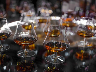 Glass of brandy or cognac on the bluring background selective focus, horizontal