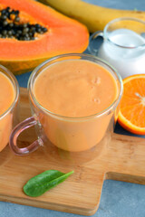 Fresh papaya, banana, orange fruit smoothie with coconut milk