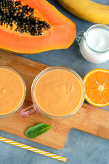 Fresh papaya, banana, orange fruit smoothie with coconut milk