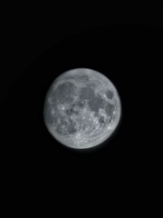 Full moon in the dark night sky. Close-up shot.