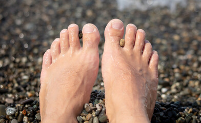 Man's foot on a pebble beach