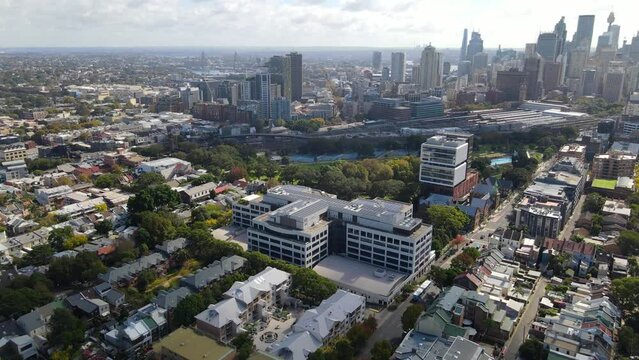 Aerial drone pullback reverse view of Redfern in inner Sydney, NSW Australia looking toward Ultimo and Haymarket   