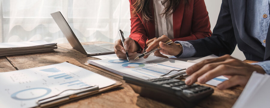 Two business people talk project strategy at office meeting room. Businessman discuss project planning with colleague at modern workplace while having conversation and advice on financial data report