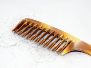 Plastic comb brush for hair and hair loss on a white background.