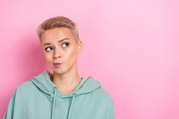 Photo of young funny pouted lips minded blonde short hair girl look empty space wear khaki hoodie think genius idea isolated on pink color background