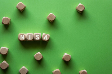 There is wood cube with the word NISA.It is an abbreviation for Nippon Individual Savings Account as eye-catching image.