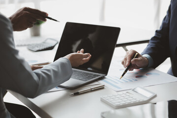 Fototapeta premium Businessman is reviewing monthly sales documents for analysis and marketing plans for more sales growth, they are the founders of young companies co-founding startups. Sales management concept.