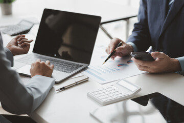 Businessman is reviewing monthly sales documents for analysis and marketing plans for more sales growth, they are the founders of young companies co-founding startups. Sales management concept.