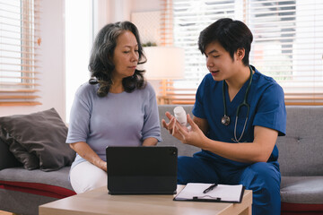 A health visitor is seen with a tablet, explaining to a senior woman how to take her pills.