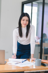 Close-up portrait of a professional, beautiful, and confident woman in casual clothing, with a friendly personality, smiling against an indoor office background. Positive human emotions. vertical