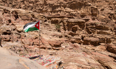 the flag of Jordan over the Ad-Deir trail, Petra, Jordan 