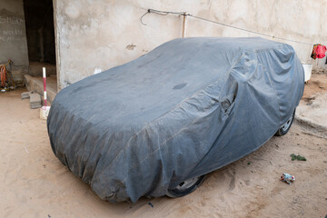 une voiture sous une bâche garée dans une rue populaire de Dakar au Sénégal en Afrique