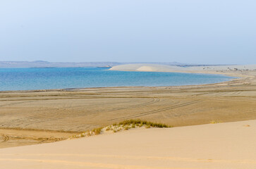 Sand dunes descending into the creek at Al-Adaid Desert in Qatar