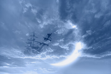 Fototapeta na wymiar Fantasy old ship flying over stormy clouds with crescent moon