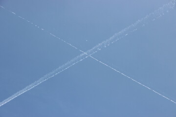 ciel avec trace d'avions formant une croix
