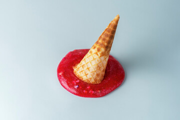 Creative sweet food concept. Ice cream dripping out of a waffle cone on the blue floor.