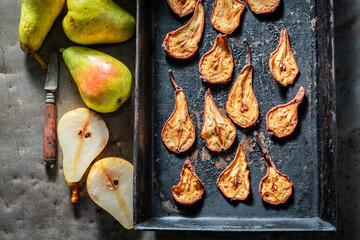 Tasty and homemade sun dried pears on old baking tray.