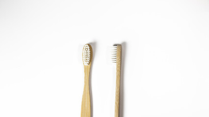Two bamboo toothbrushes on white background, top view, copy space