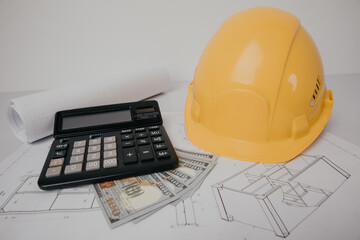 Construction drawings with helmet, calculator and money. Building costs