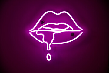 Purple neon sign with leaking saliva hanging on club wall