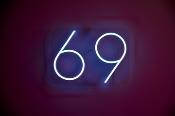 Blue neon sign with number 69 attracts tourist attention