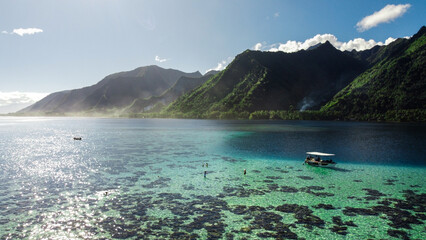 Photo de Tahiti en Polynésie Française. Vue d'un drone avec l'océan et les montagnes. Bateau de tourisme faisant visiter le littoral.