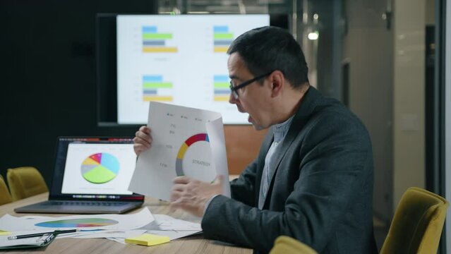 Portrait of a manager in formal suit and glasses working in modern office space. Close-up of financial expert showing annual results in a conference. High quality 4k footage