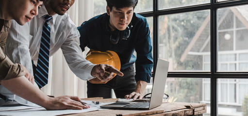 Civil engineer teams meeting working together wear worker helmets hardhat on construction site in modern city. Foreman industry project manager engineer teamwork. Asian industry professional team.