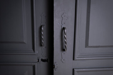 a beautiful gray door with iron handles is open