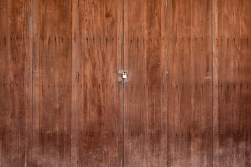 The key lock with brown old wooden door, pattern, texture for background.