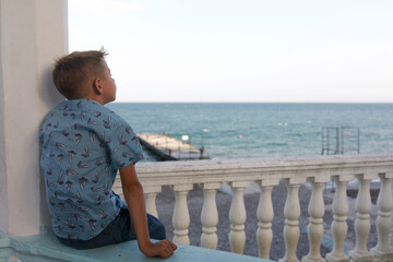 Fototapeta na wymiar Kid relaxing on embankment of Yalta