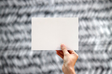 Hand holding blank card on blur texture background