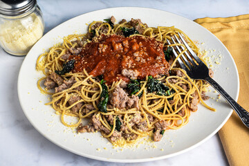 wheat spaghetti top with crumble sausage  and spinach,