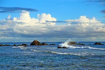 Blue sea and white waves crashing rocks on the water. Cloudy sky in Morro Sao Paulo, Bahia, Brazil